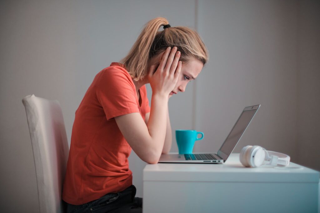 Mujer preocupada mirando la notebook con la cuenta bloqueada