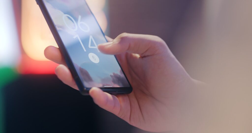 Persona desbloqueando el celular con la huella para abrir el gestor de contraseñas