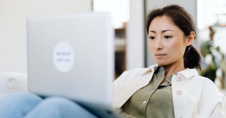 Mujer creando su cuenta de PayPal paso a paso desde una laptop en casa