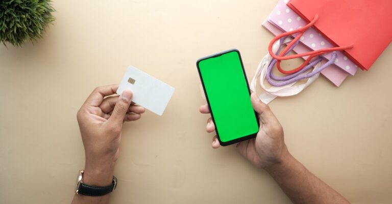 Persona usando una tarjeta de debito y el celular para abrir una cuenta de PayPal sin tarjeta de credito