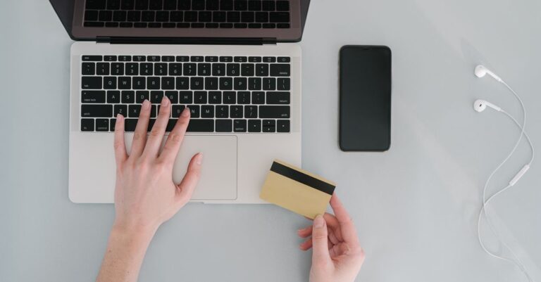 Escritorio con laptop tarjeta y celular para comprar y pagar seguro por internet