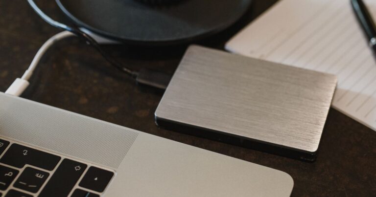 Respaldo de fotos en un disco junto a una laptop