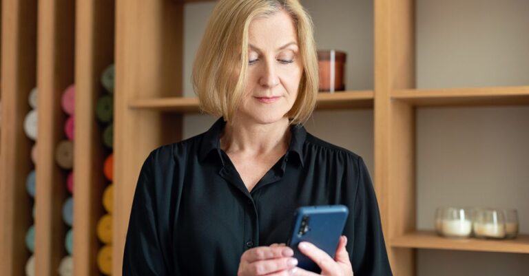 Mujer revisando su correo seguro en el celular para evitar fraudes de pago
