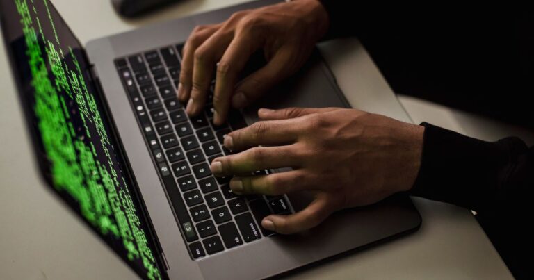 Manos tecleando en una laptop, concepto de cuenta de Google hackeada