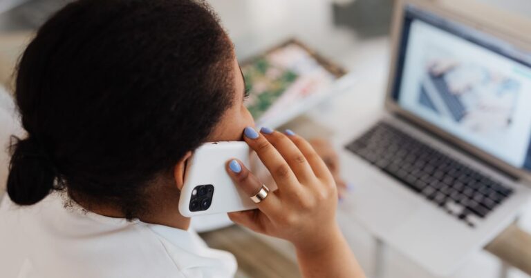 Mujer revisando su celular y su laptop para recuperar el acceso sin el telefono anterior