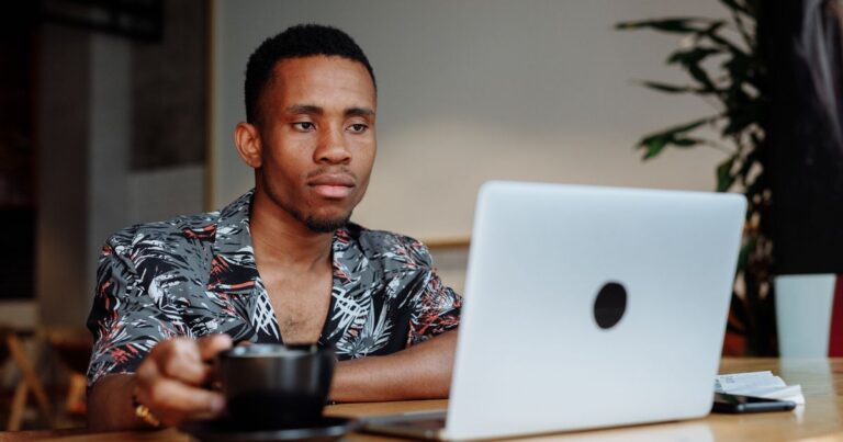 Persona usando su laptop en un cafe conectada a una red publica, concepto de VPN
